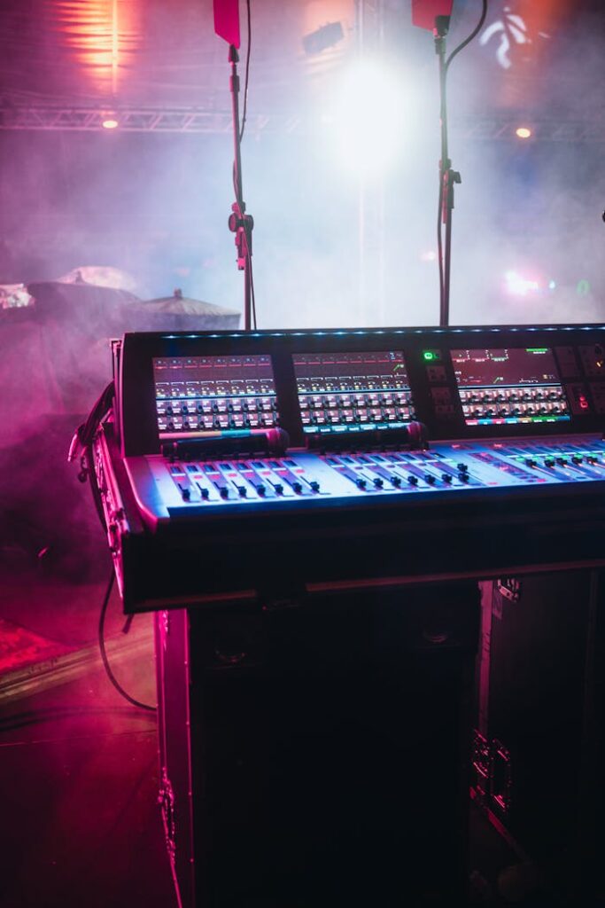 pexels-photo-12262186 A vibrant shot of a professional audio mixer on a stage under colorful lights, ready for a live performance.